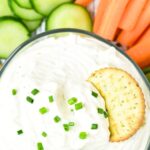 Top down view of cracker in a bowl of cottage cheese ranch dressing dip