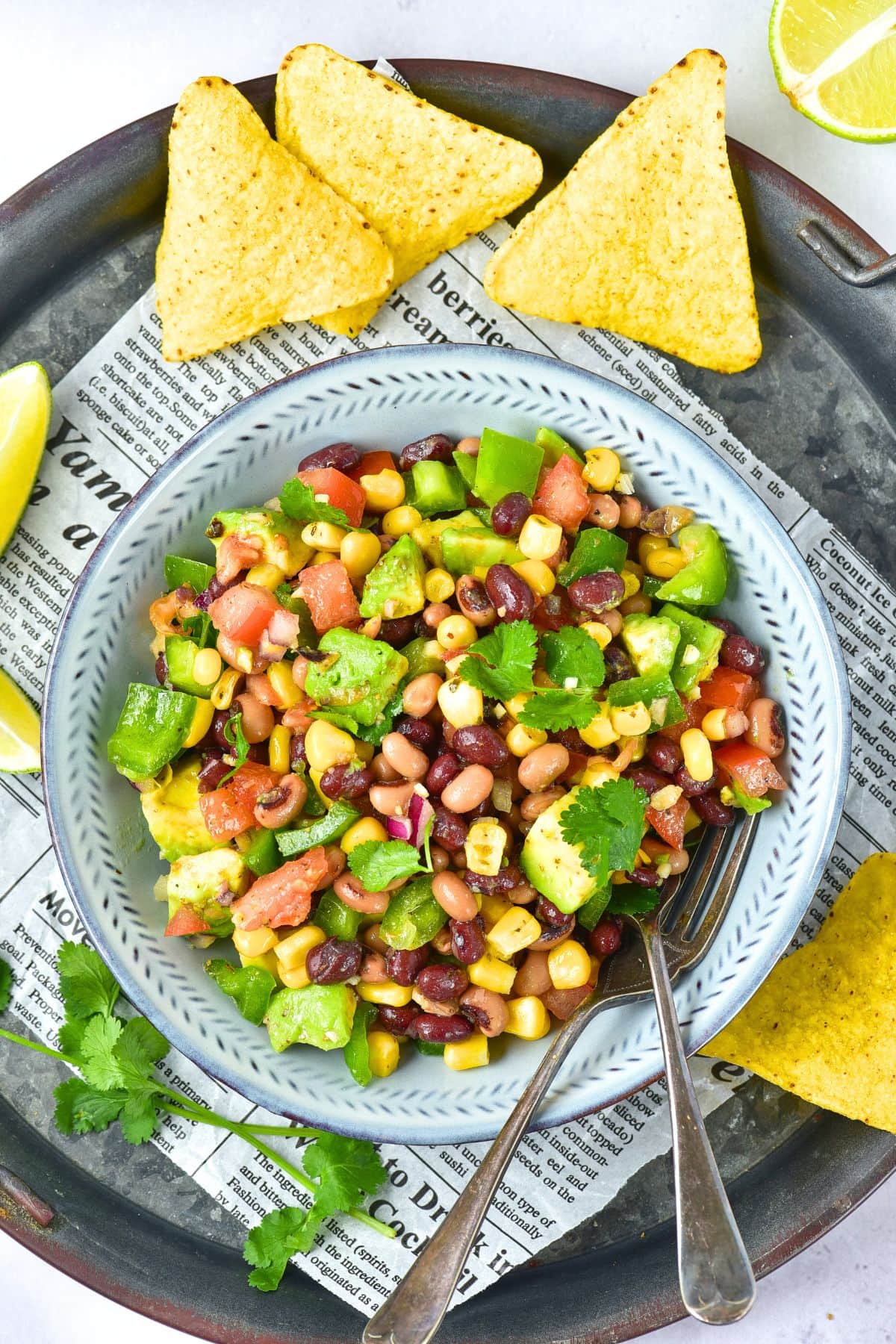 A bowl of bean salad with avocado and cilantro