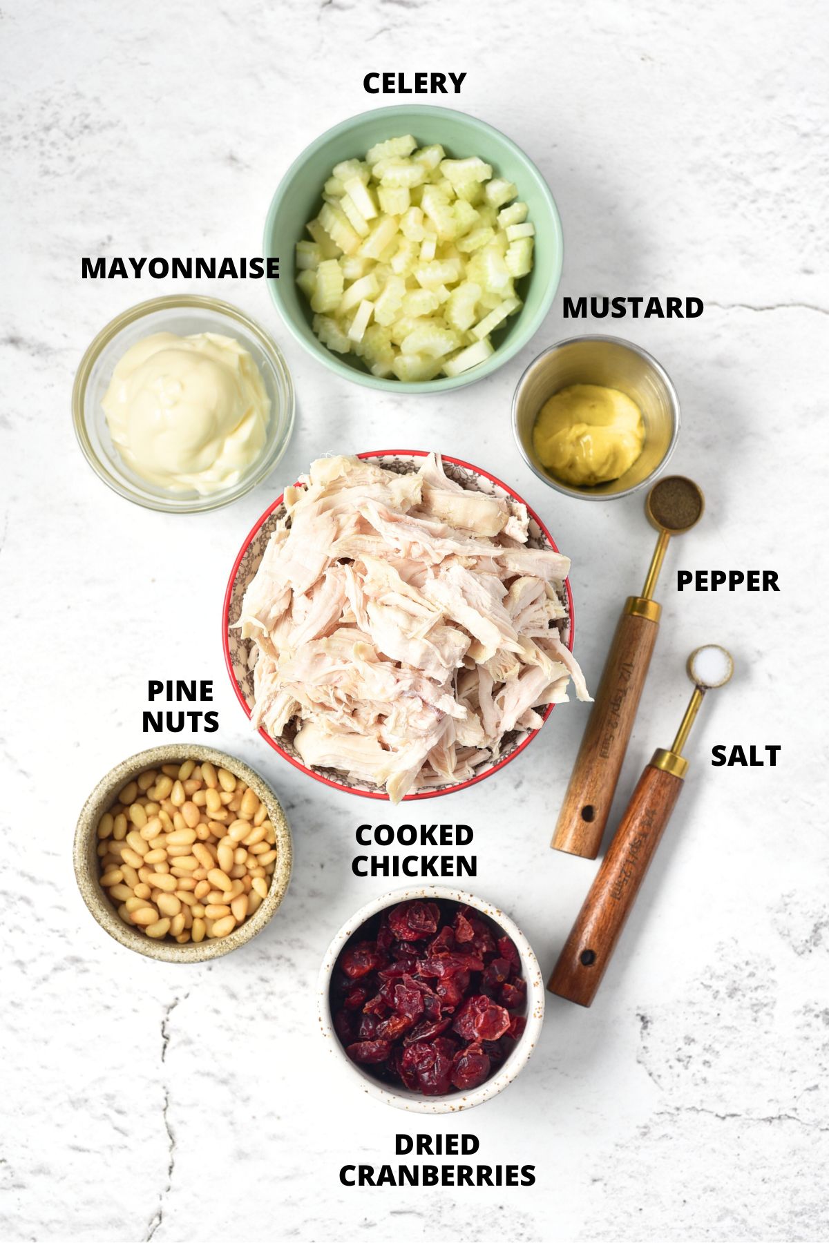Ingredients for cranberry chicken salad recipe laid out on marble board.