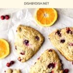 Top down view of orange cranberry scones on parchment paper.