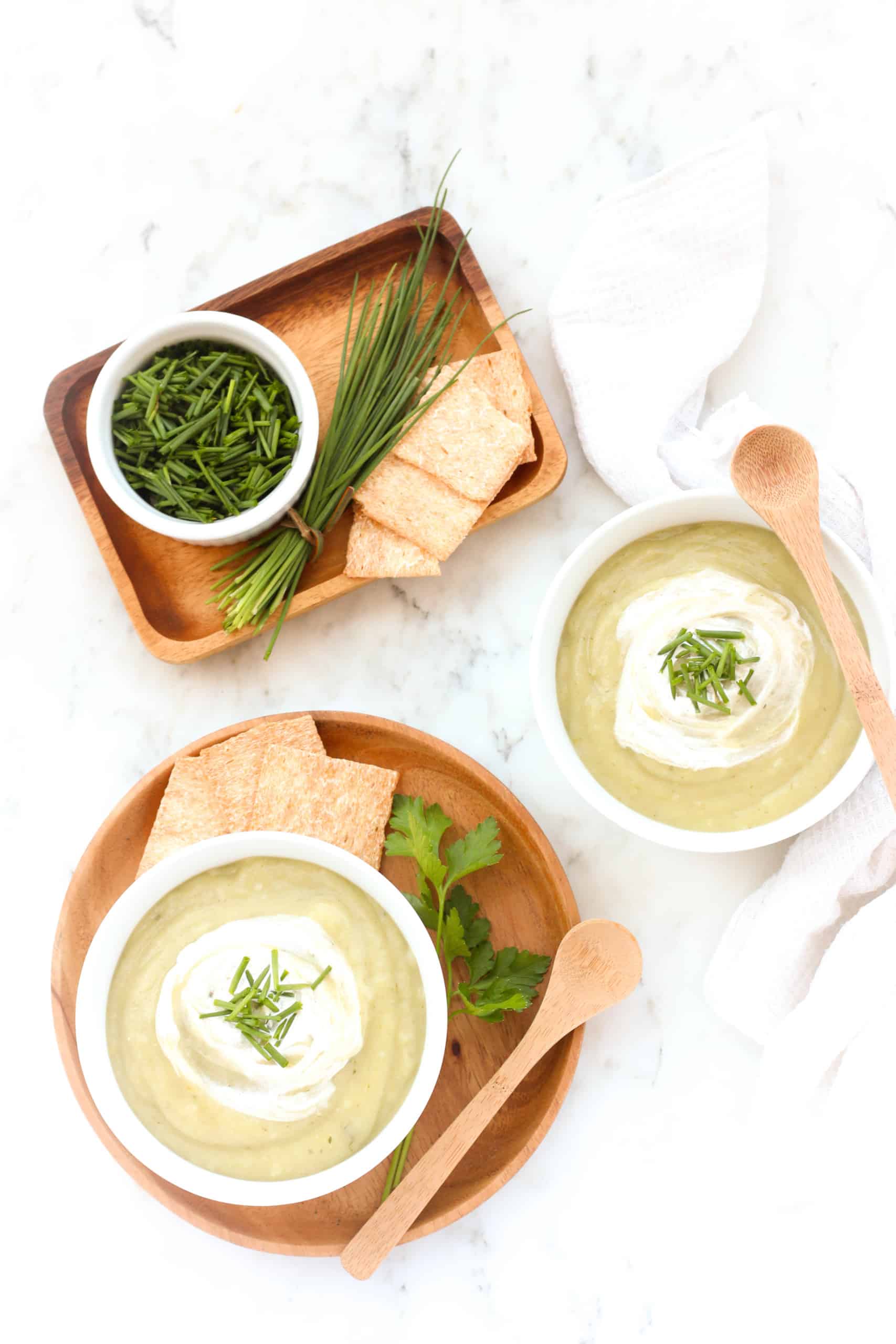 Bowls of gluten-free potato soup on a marble board.