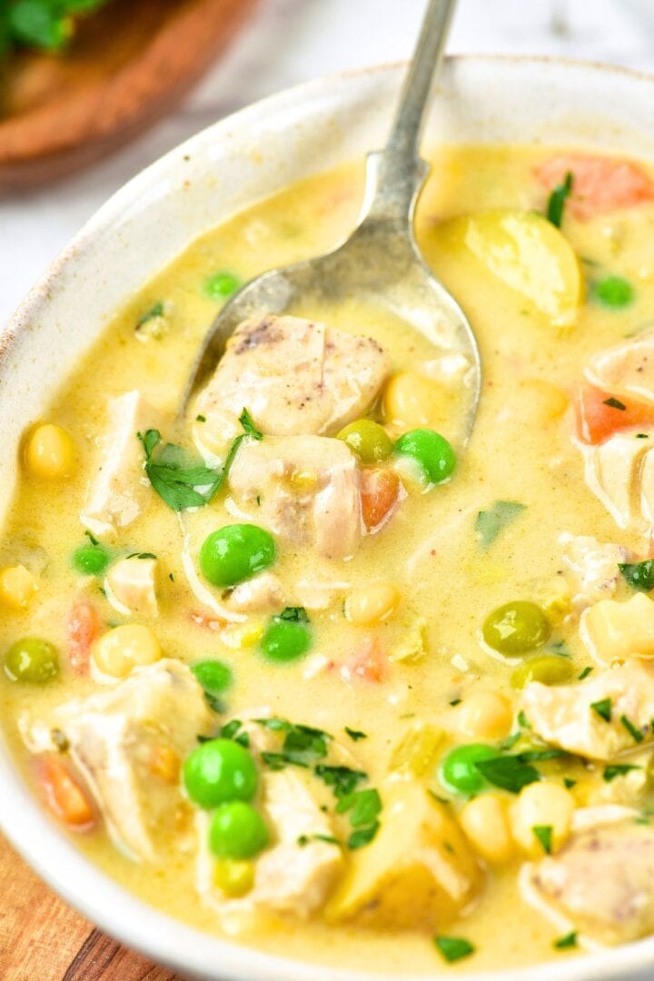 A spoon in a bowl of gluten-free creamy chicken and potato soup 
