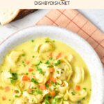 Top down view of a bowl of tortellini soup with chicken