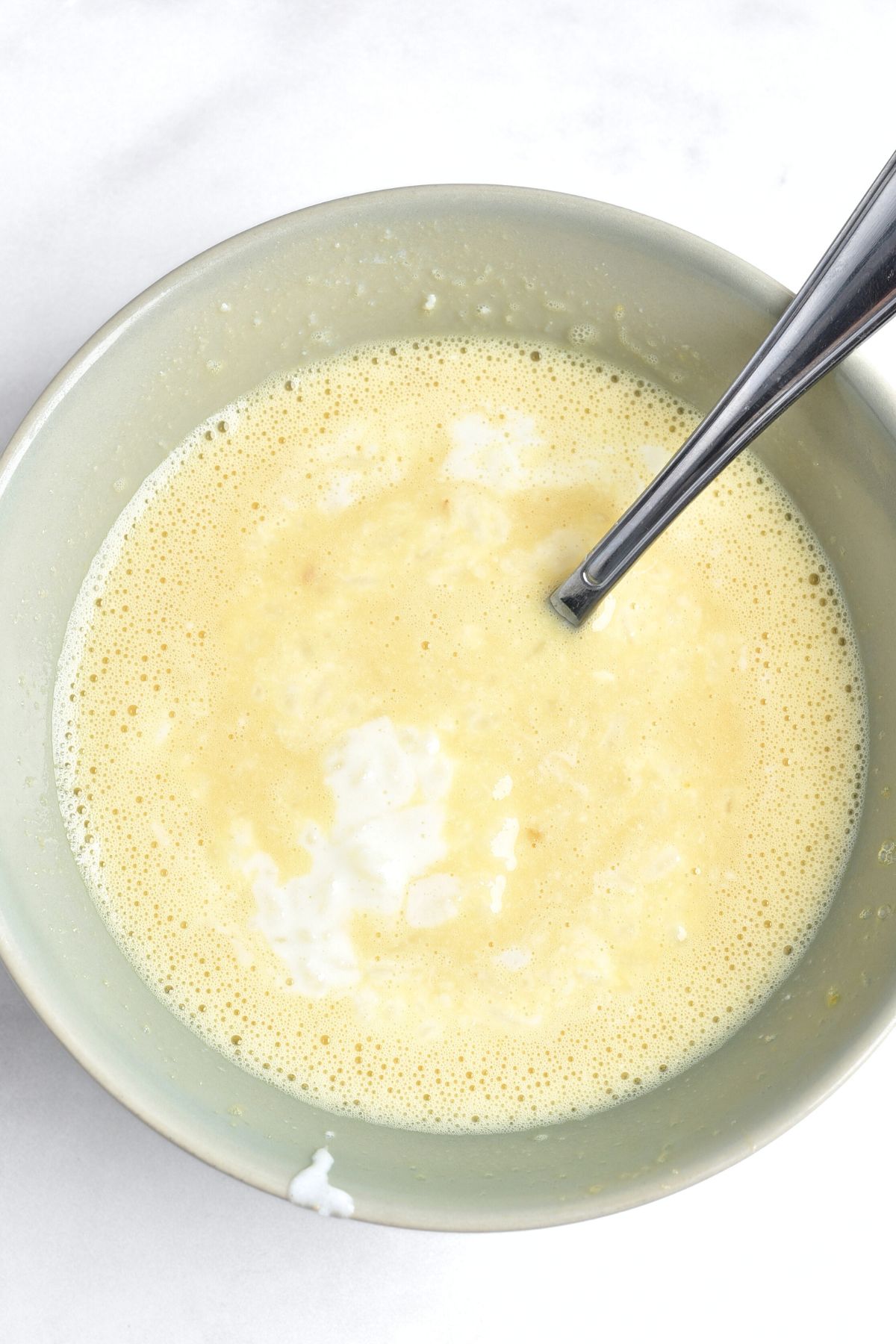 Mixing yellow liquid mixture in green bowl