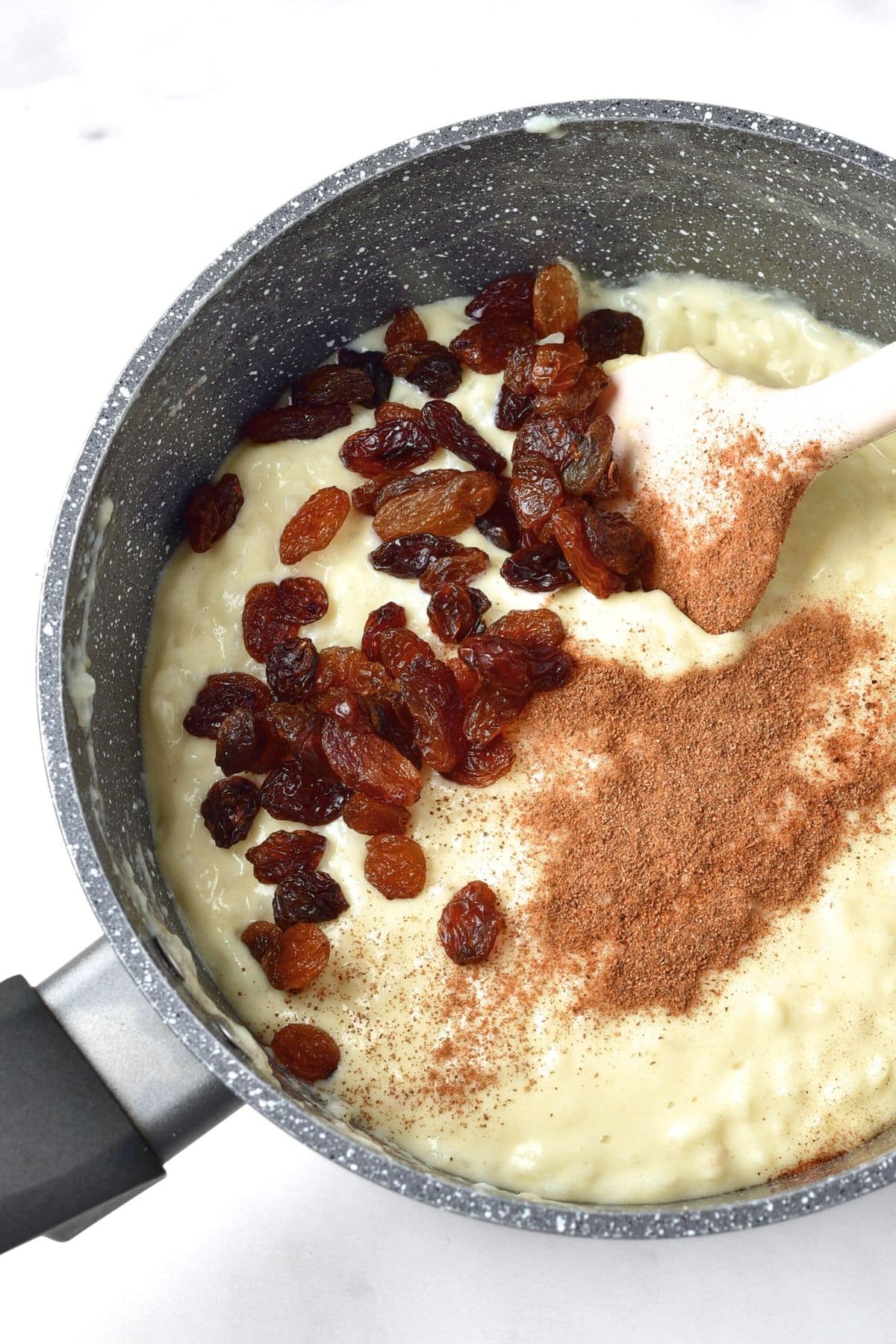 Mixing raisins and spices into creamy rice pudding