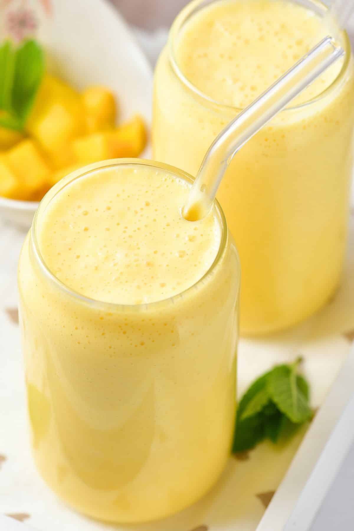 Up close shot of a glass of mango milkshake