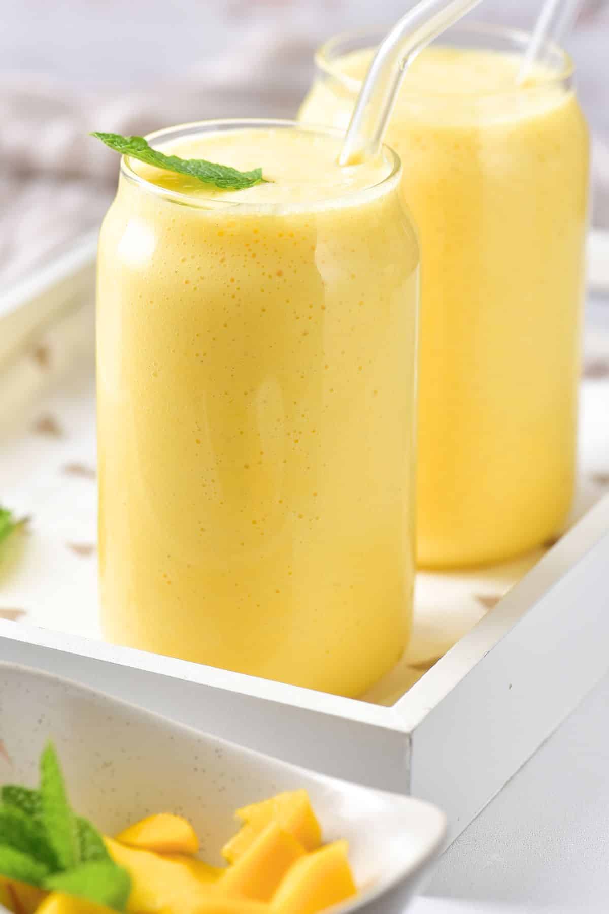 Up close shot of easy mango milk shake in glasses.