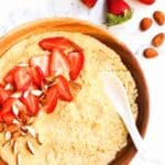 Top down view of a bowl of millet porridge with fresh strawberries.