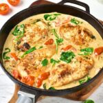 Creamy Tuscan chicken in cast iron skillet.