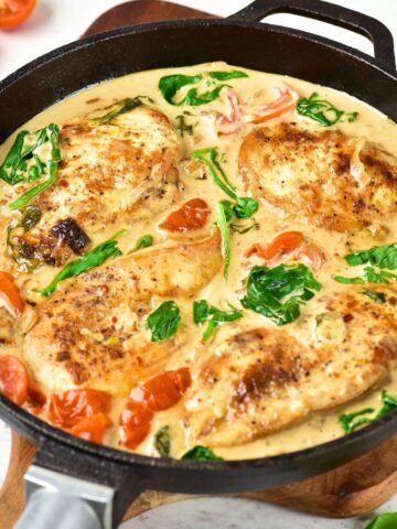 Creamy Tuscan chicken in cast iron skillet.