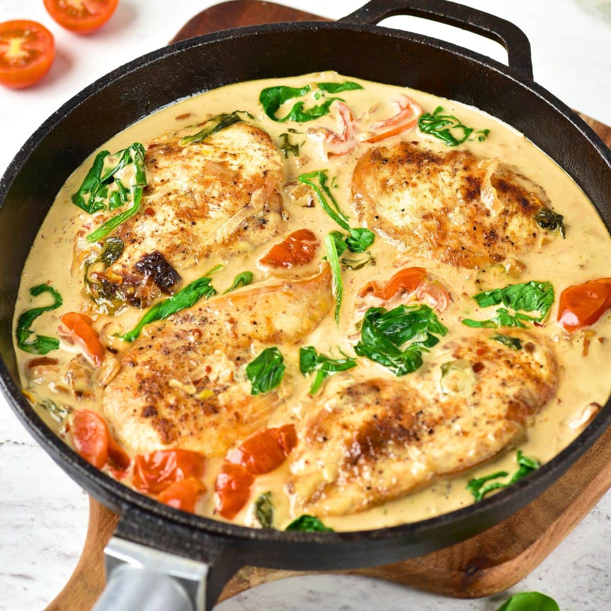 Creamy Tuscan chicken in cast iron skillet.
