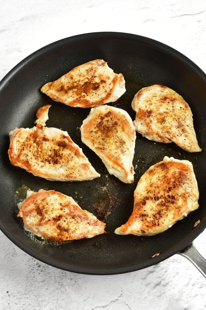 Seared chicken breast fillets in skillet