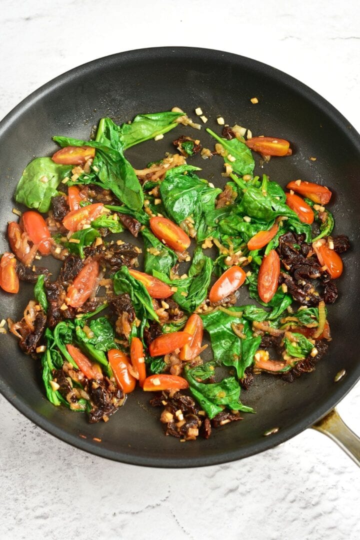 Cooked tomatoes, spinach and garlic in nonstick skillet