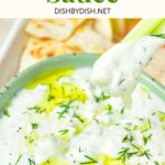 Dipping a celery stick into a bowl of tzatziki dip