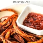 Up close shot of sweet potato fries with a bowl of ketchup.