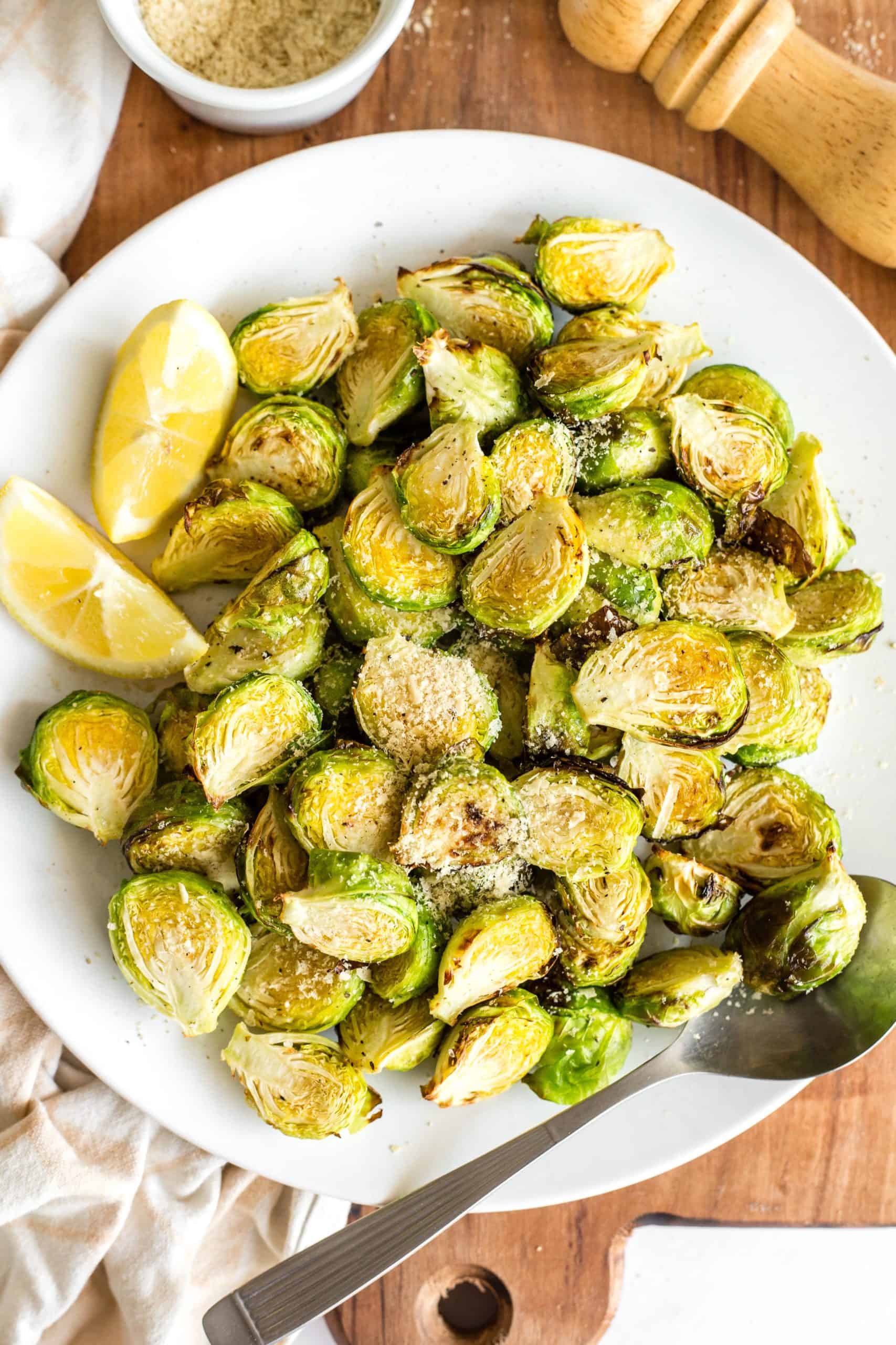 A plate of crispy Brussels sprouts on a wooden board.
