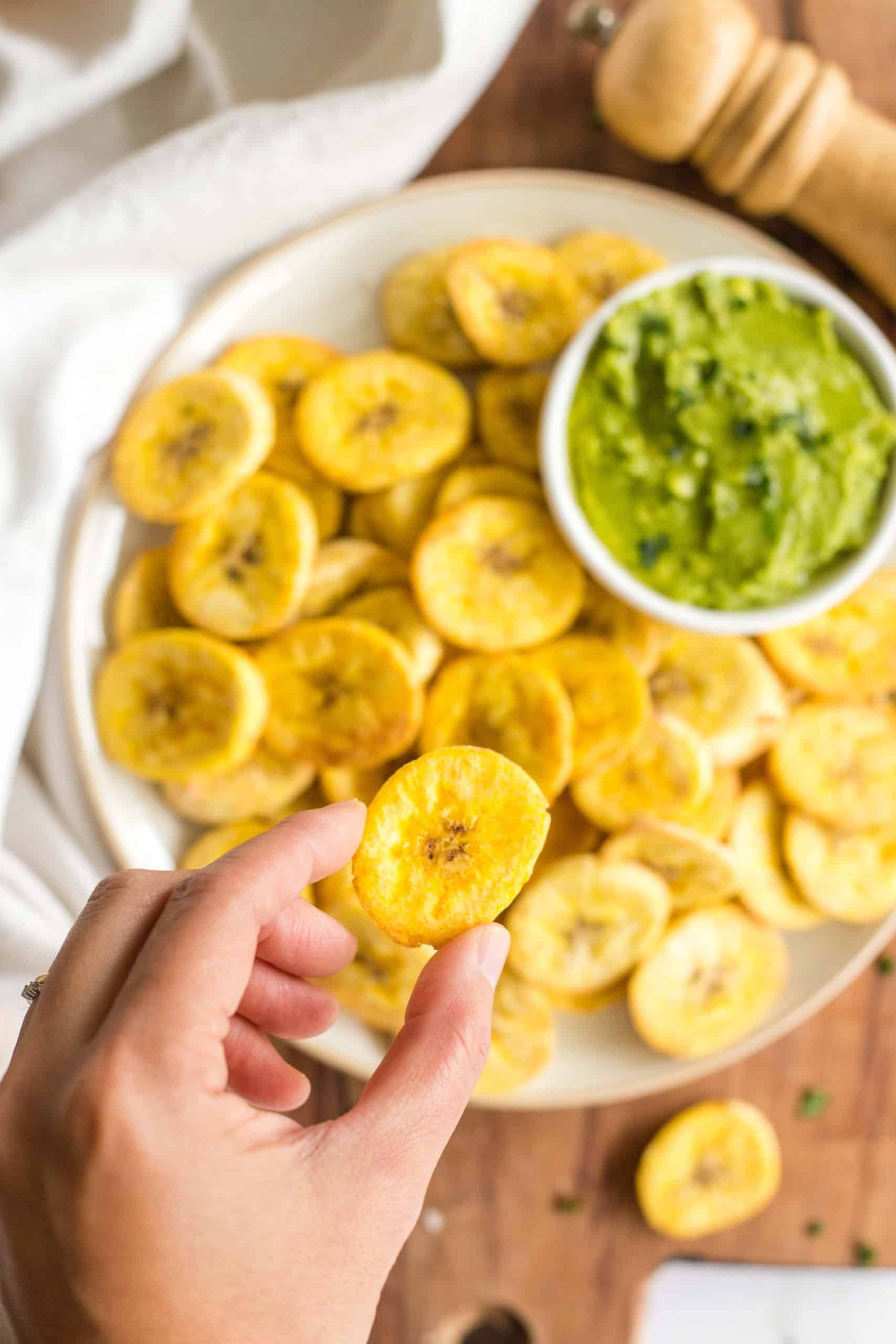 Holding up a crispy plantain chip.