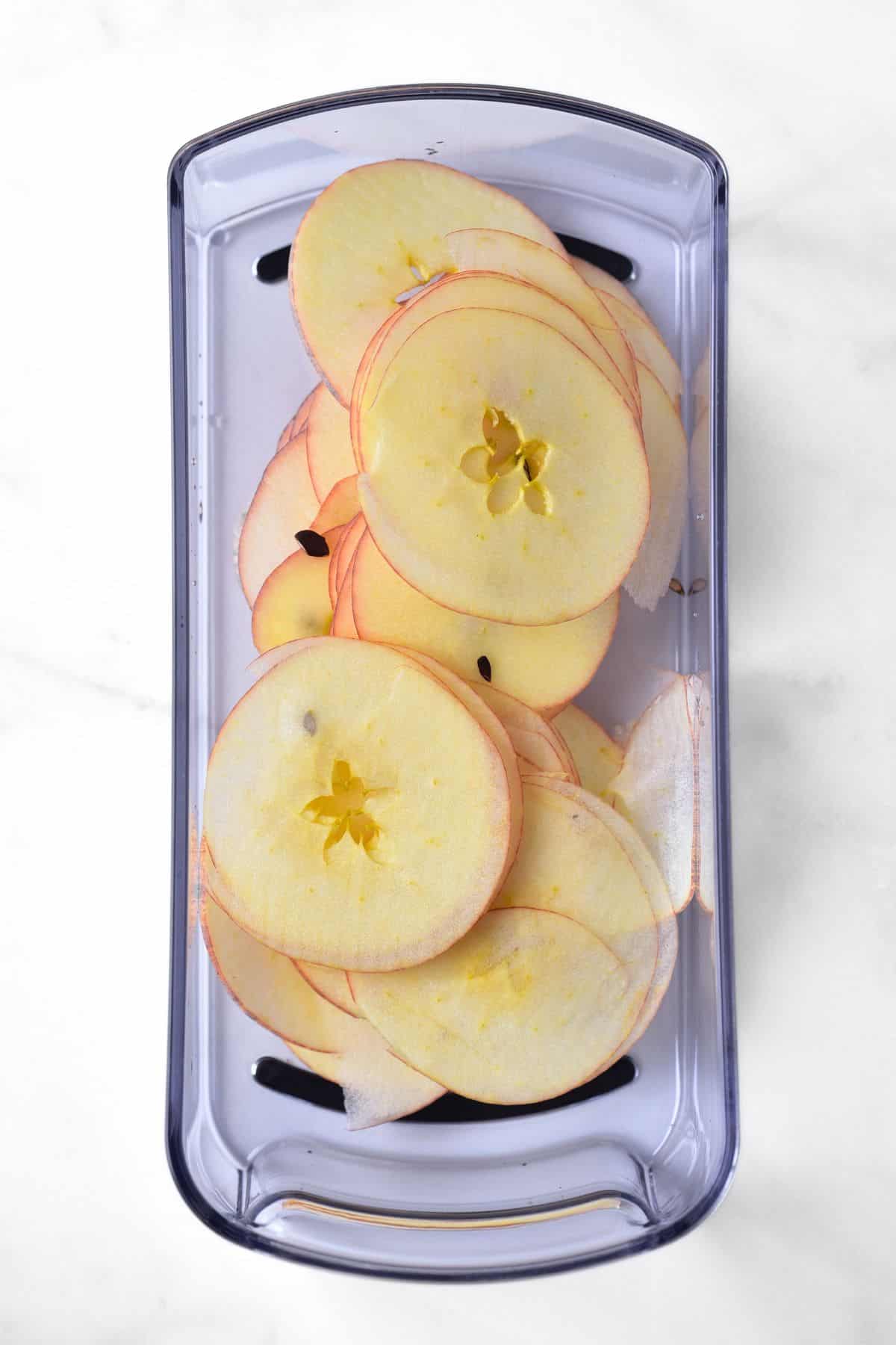 Thin apple slices on mandoline slicer.