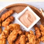 Top down view of chicken fingers on basket.