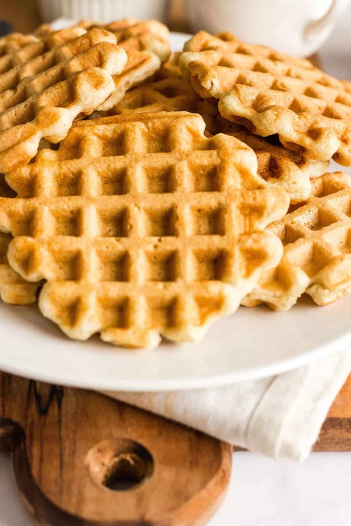 A plate of gf df waffles on wooden board.