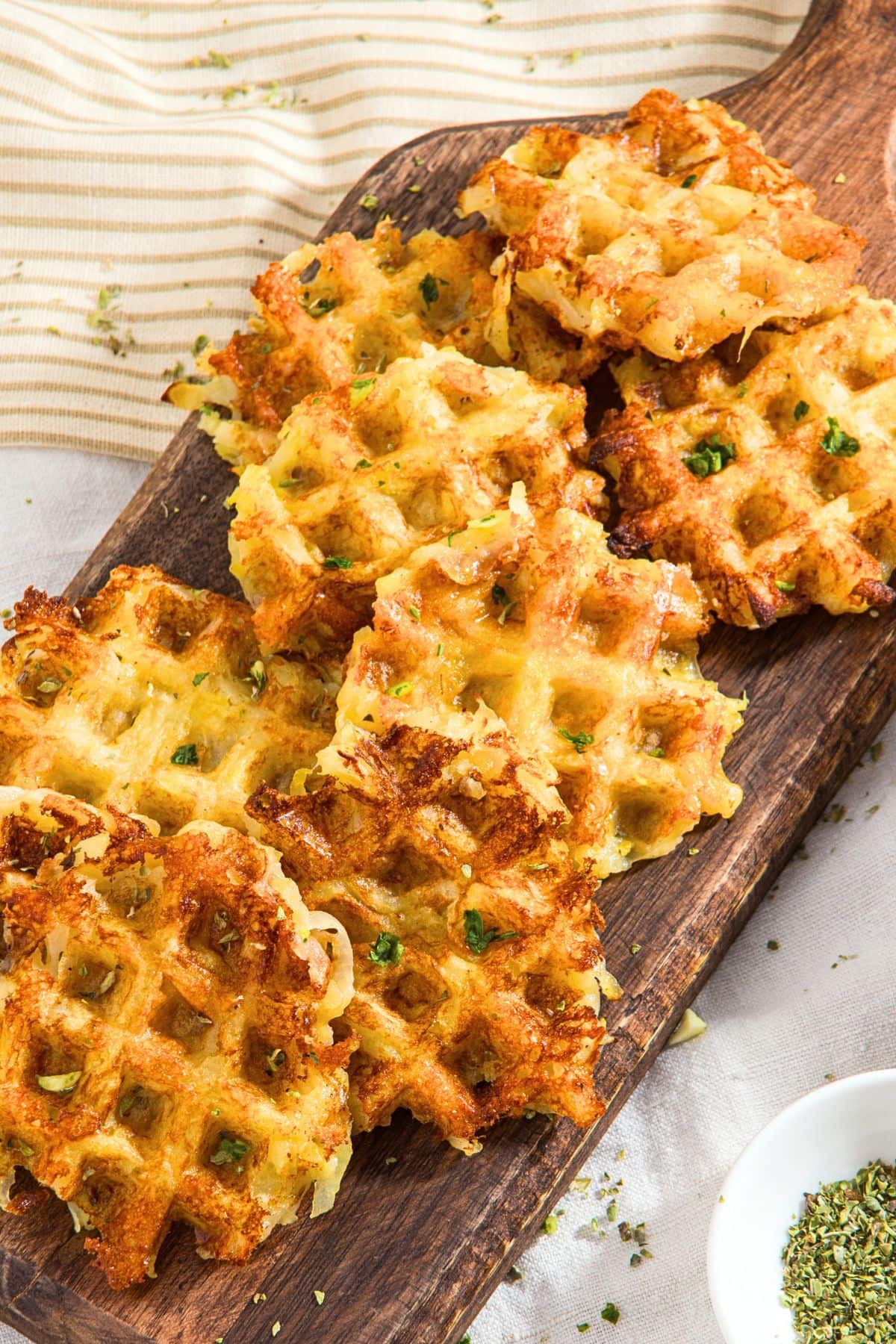 Crispy hash brown waffles on wooden board.