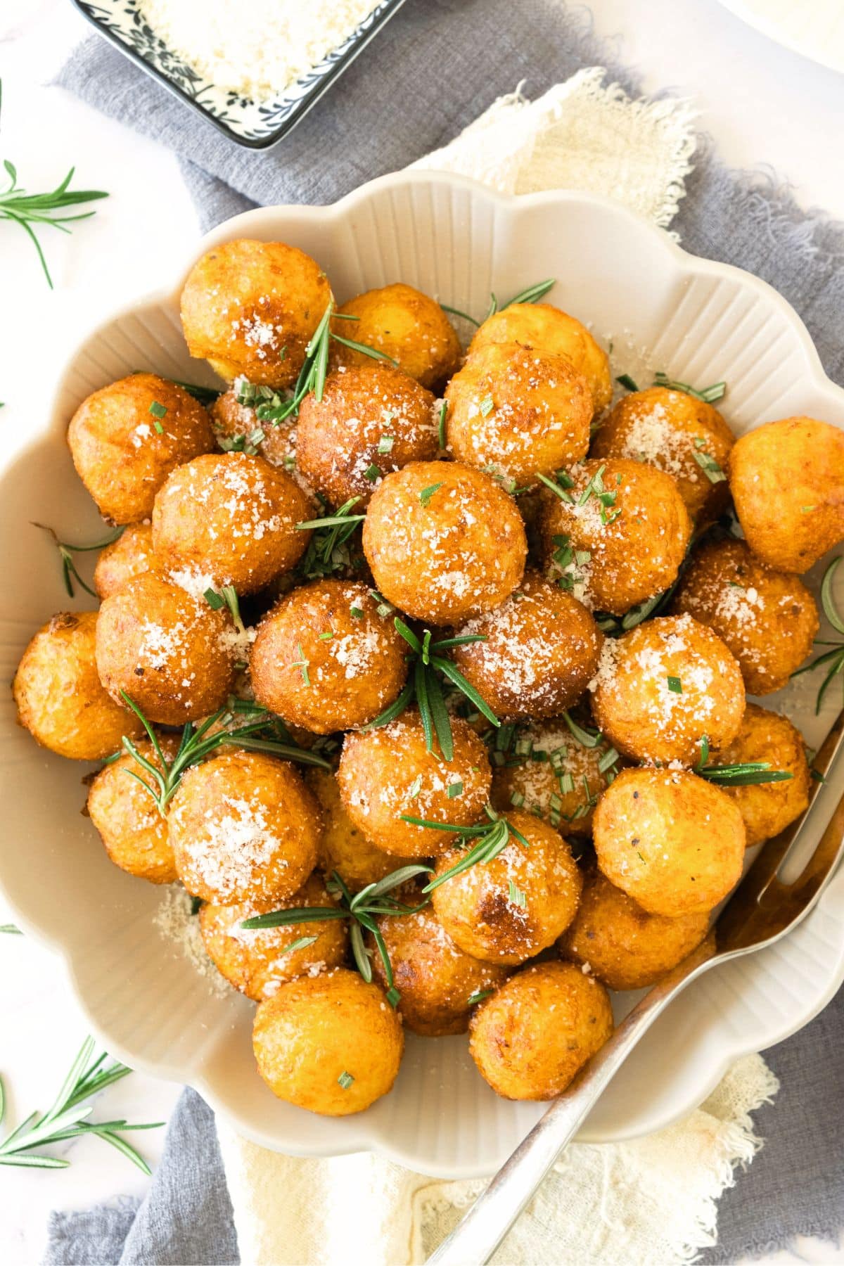 A plate full of crispy fried potato balls.