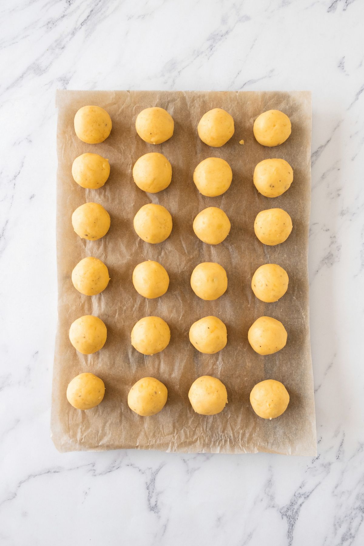 Mashed potato balls on parchment paper.