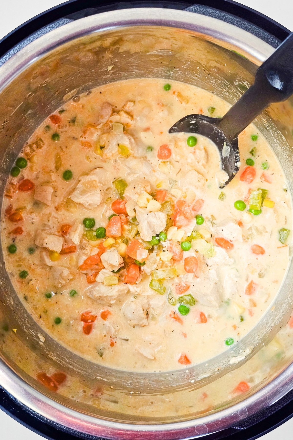Mixing chicken soup with a ladle.