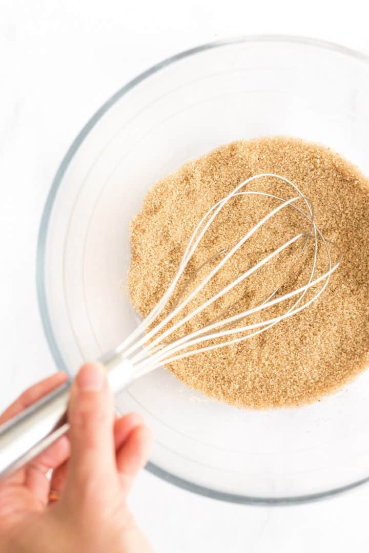 Whisking brown sugar in glass mixing bowl.