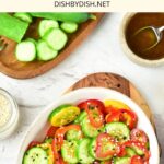 A bowl of cucumber and pepper salad on wooden board.
