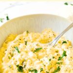 A spoon in a bowl of egg salad.