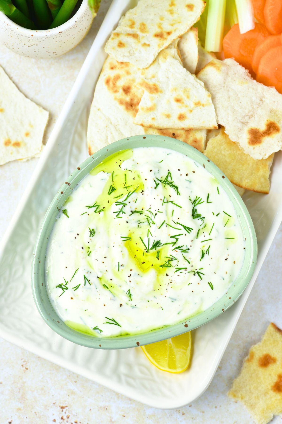 Top down view of a bowl of dill tzatziki and crackers
