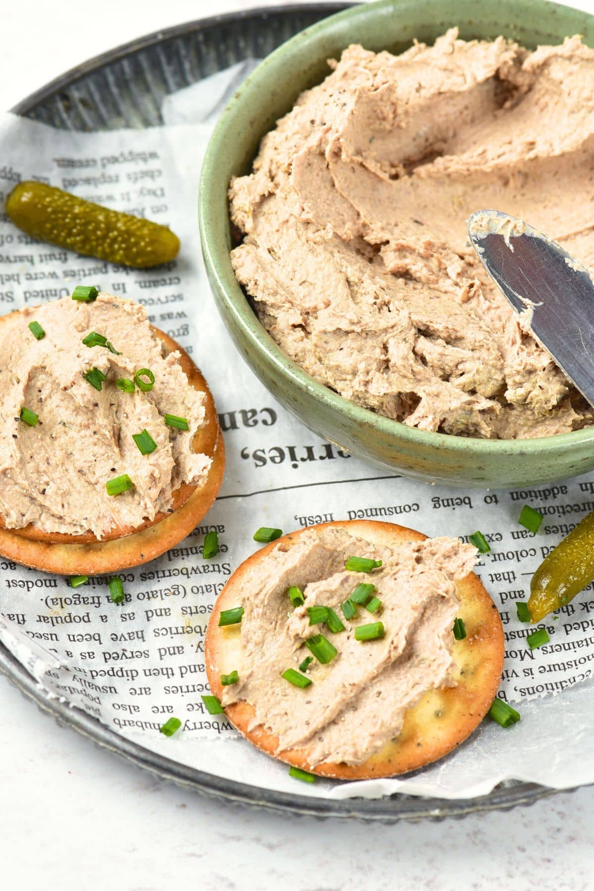 Crackers spread with duck liver pate and a bowl of pate.