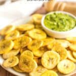A plate of plantain chips on wooden board.