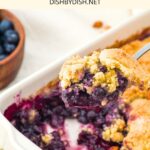 Holding up a spoonful of gluten-free blueberry cobbler.