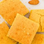Top down view of cornbread squares on parchment paper.