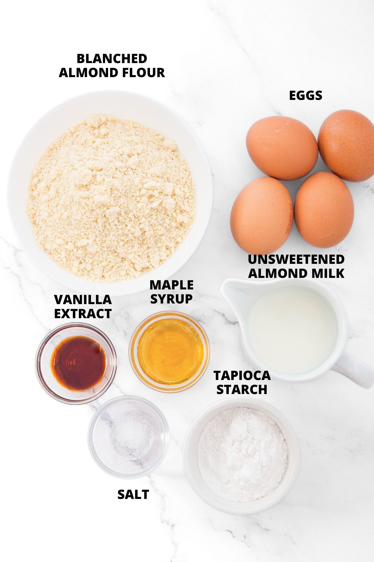 Ingredients for almond flour crepes recipe laid out on marble board.