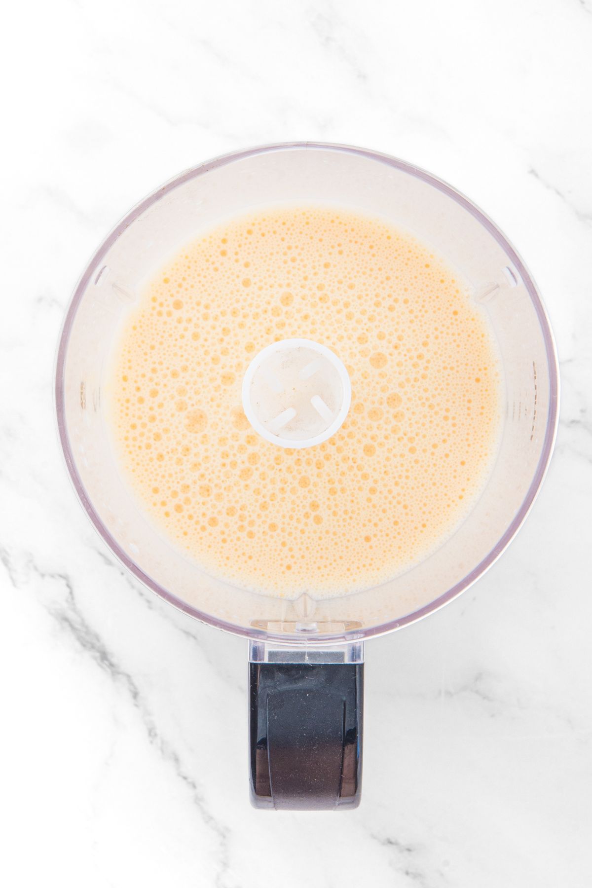 Pale yellow almond flour crepe batter in food processor.