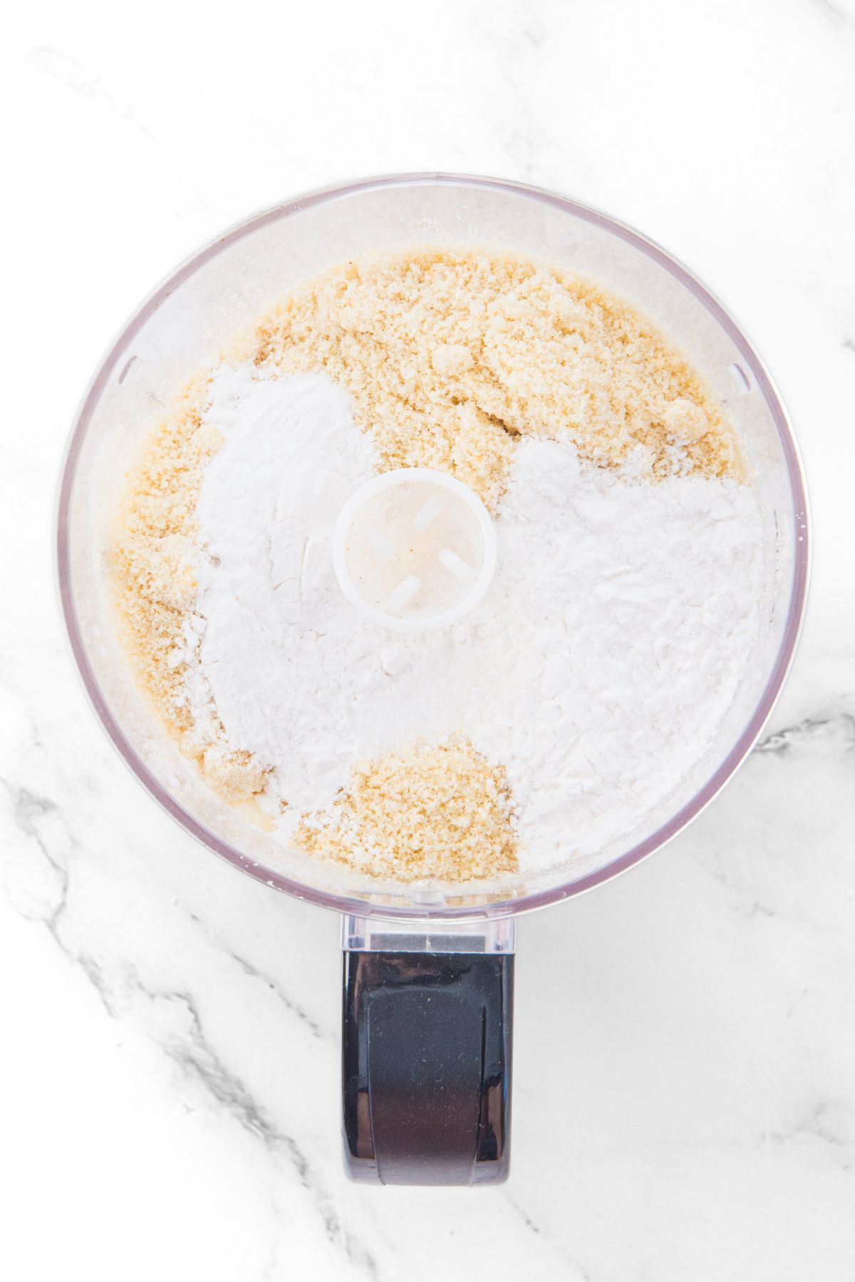Almond flour and tapioca starch in food processor.