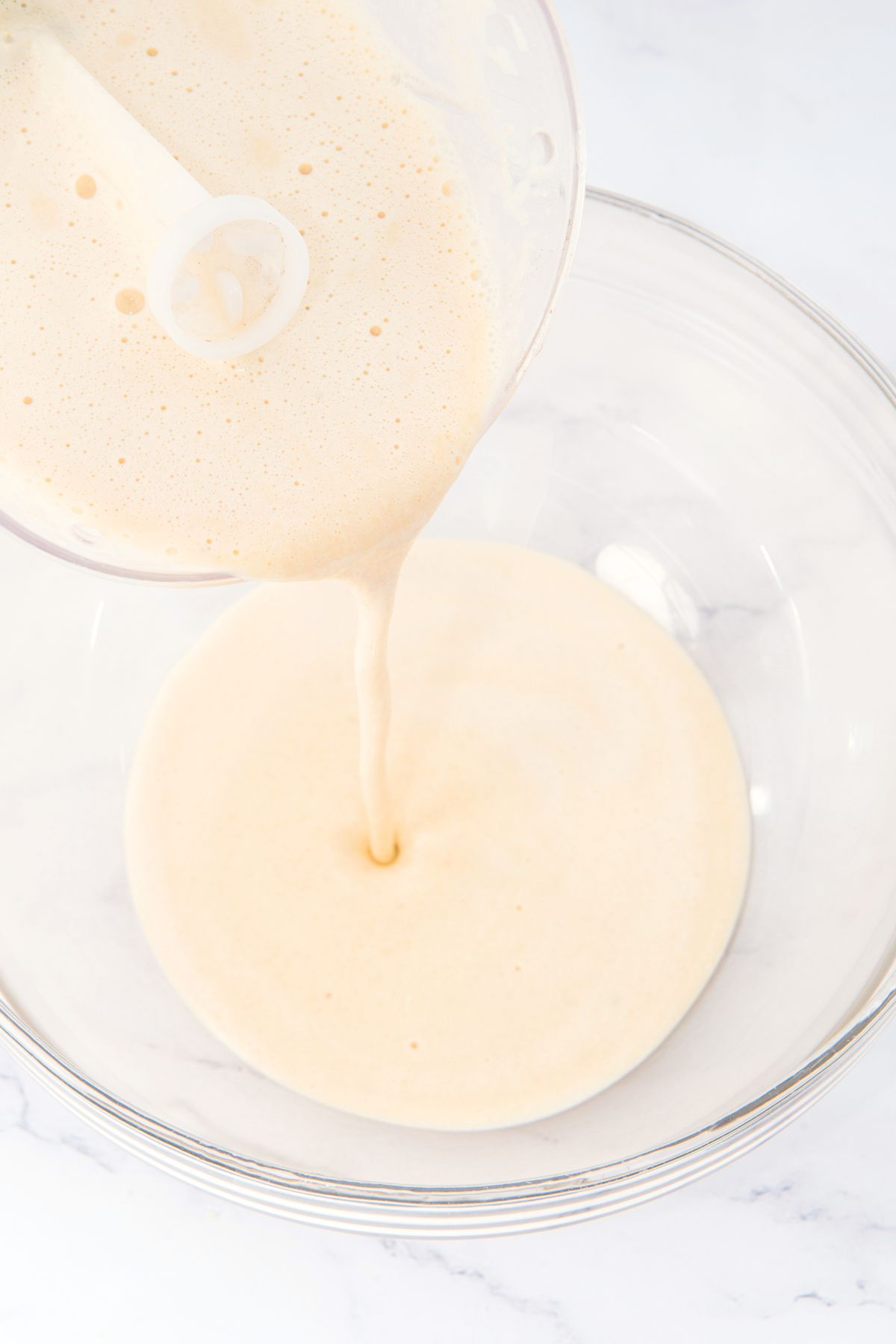 Pouring crepe batter into a glass bowl