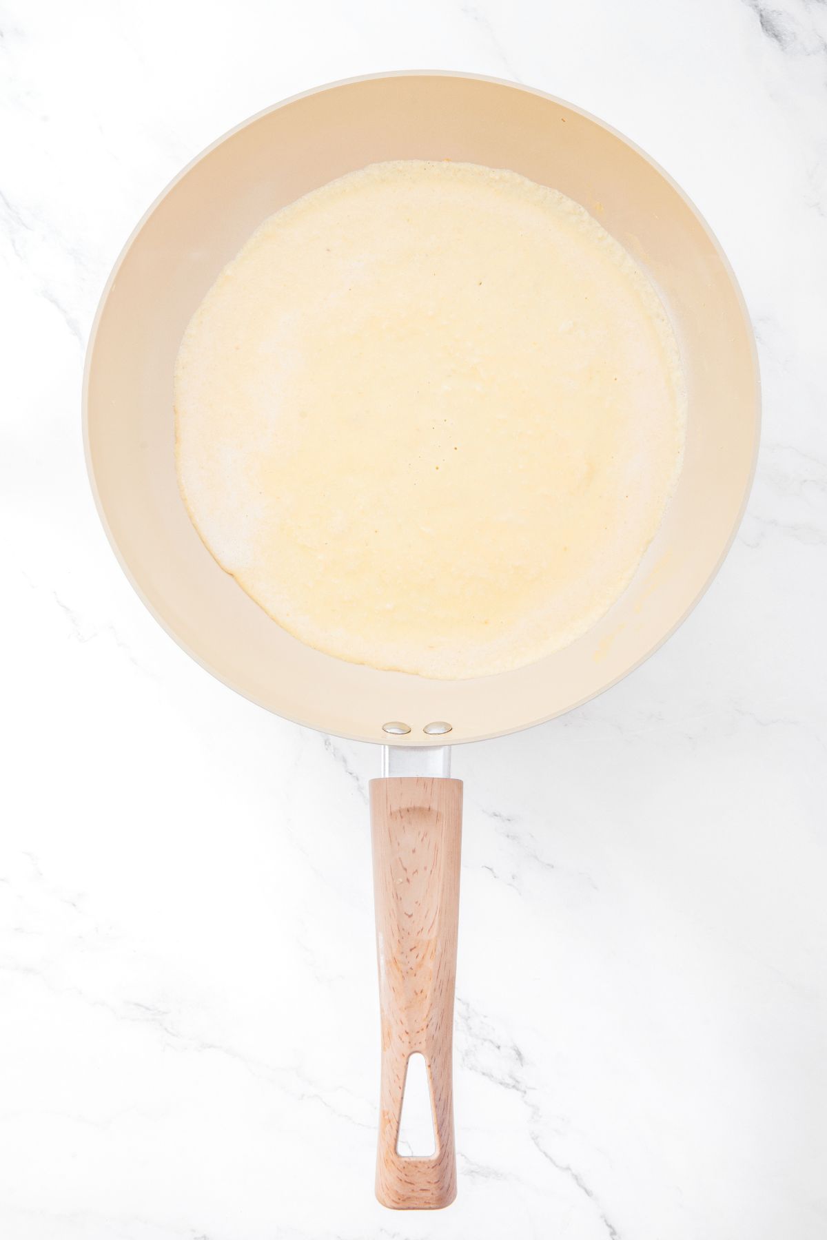 Raw crepe batter in skillet
