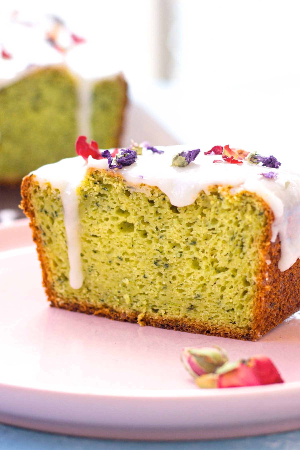 GF Avocado Cake Recipe A half-sliced avocado cake with lemon glaze.