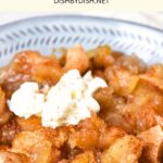 A bowl of baked apple slices topped with whipped cream