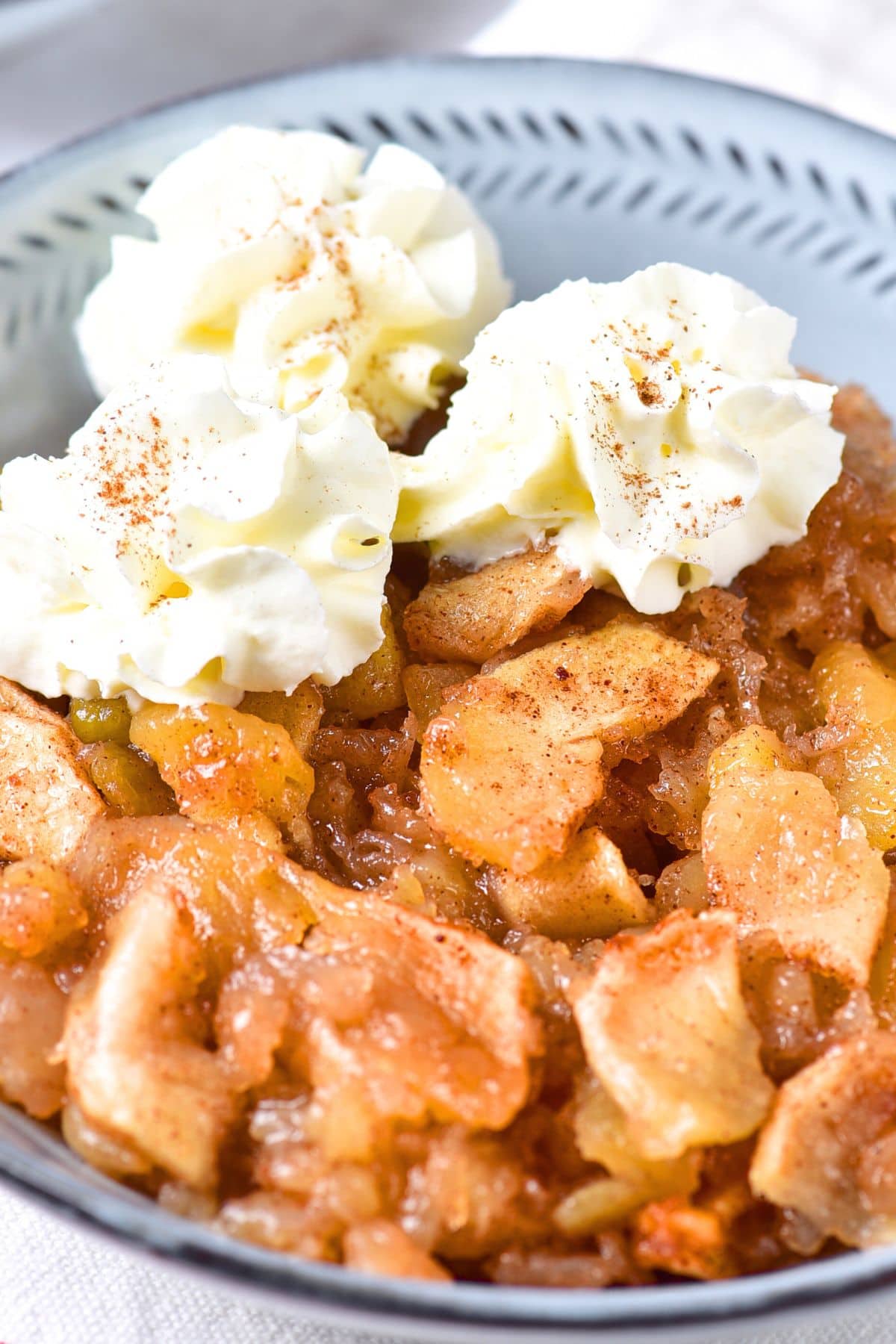 A bowl of easy baked apples topped with whipped cream.
