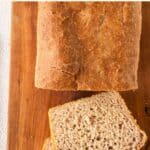 Top down view of slice loaf of gluten-free bread on wooden board.