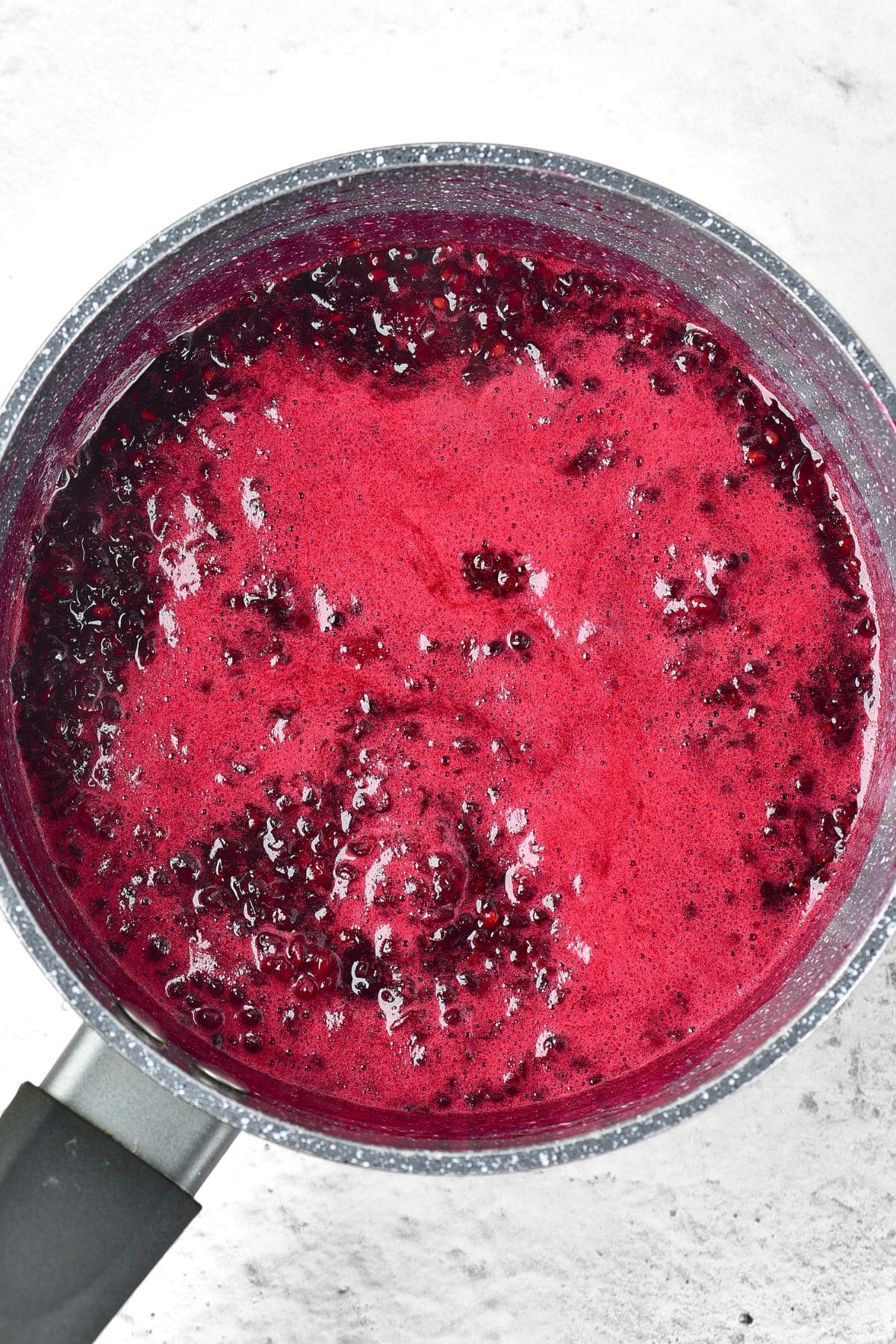 Cooking blackberries in saucepan with top layer of foam