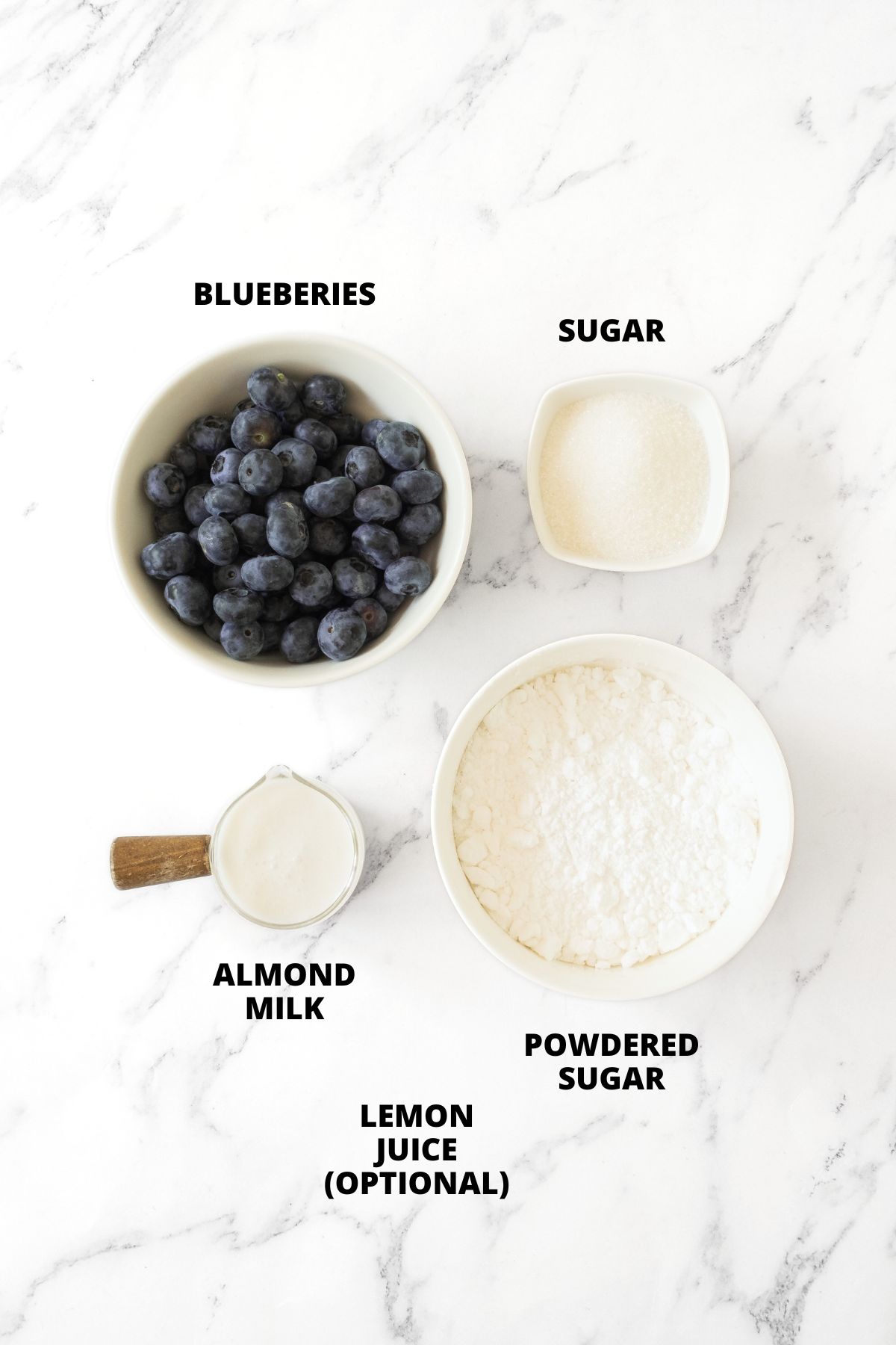 Ingredients for homemade blueberry glaze recipe laid out on marble board.