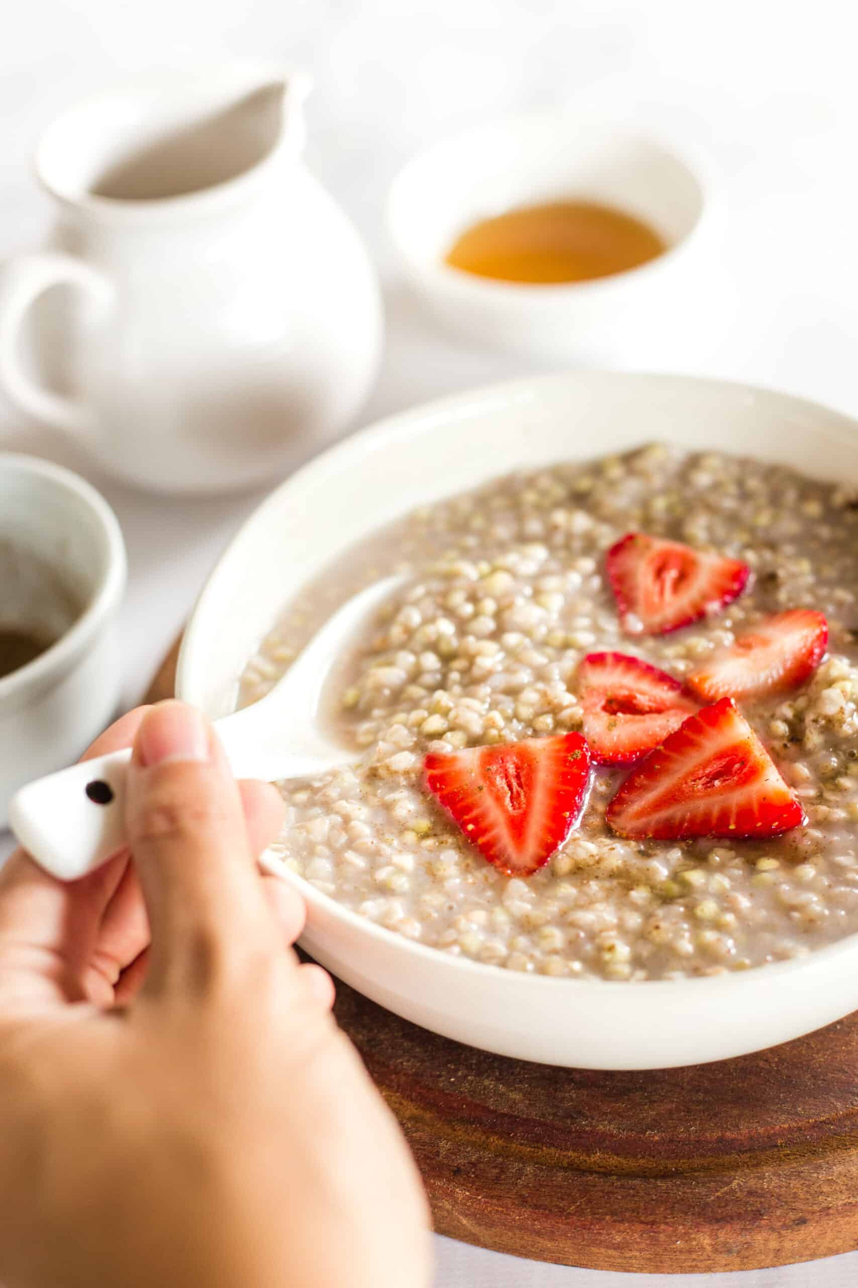 Reaching for a spoonful of buckwheat porridge and strawberries.