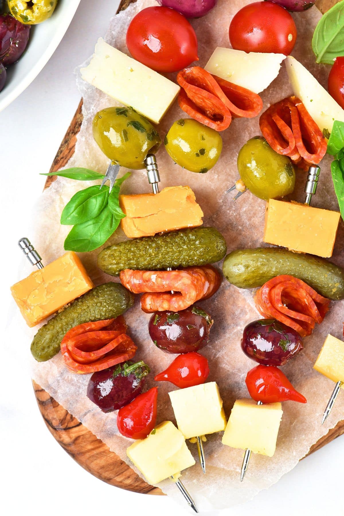 Top down view of charcuterie board skewers on wooden board.