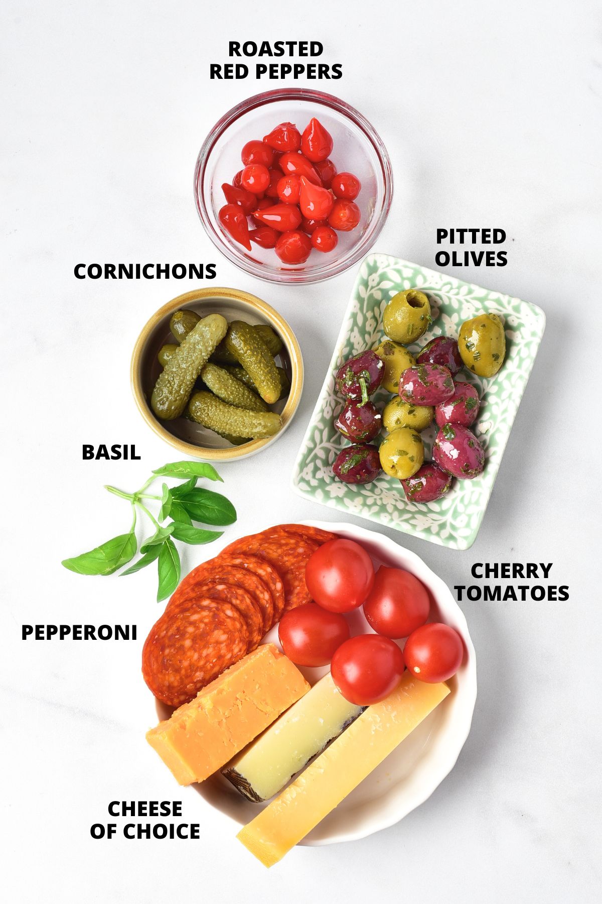 Ingredients for charcuterie skewers recipe laid out on marble board.